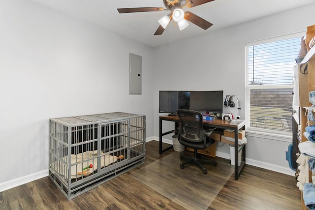 office space featuring electric panel, a ceiling fan, baseboards, and wood finished floors