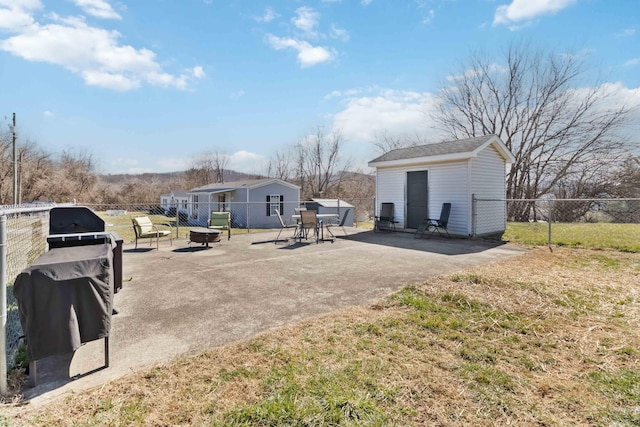 view of yard with an outbuilding, a fenced backyard, an outdoor fire pit, and a patio