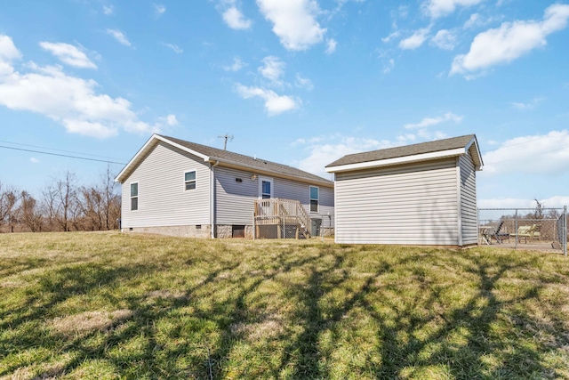 back of house featuring an outdoor structure, a yard, and fence