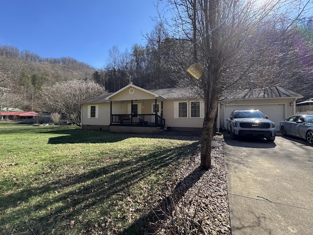 ranch-style home featuring a front yard, covered porch, driveway, and an attached garage