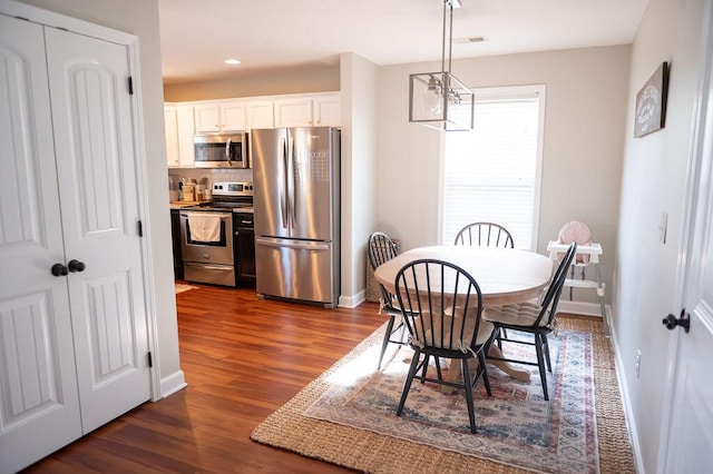 dining room with dark wood-style flooring, recessed lighting, and baseboards