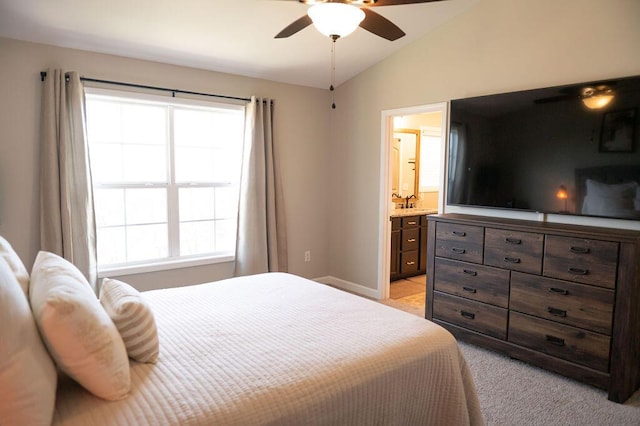 bedroom with a ceiling fan, light carpet, connected bathroom, vaulted ceiling, and baseboards