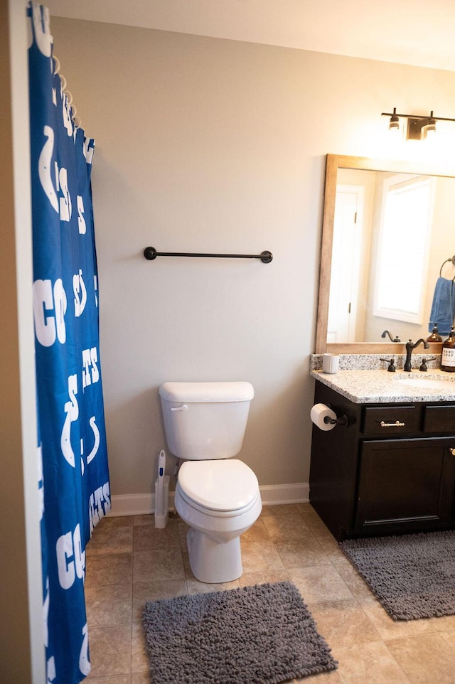 bathroom featuring a shower with curtain, vanity, toilet, and baseboards