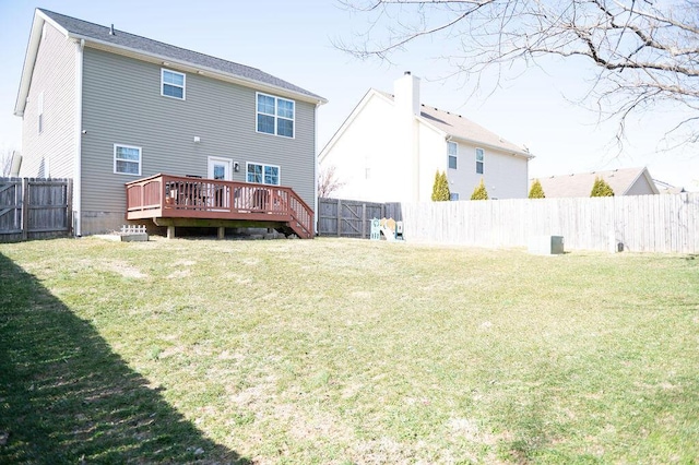 rear view of property with a fenced backyard, a wooden deck, and a yard