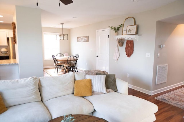 living room with baseboards, visible vents, ceiling fan, and dark wood-type flooring