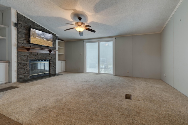 unfurnished living room with a textured ceiling, carpet, a fireplace, and crown molding