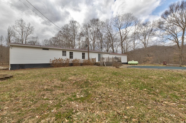 back of house featuring a deck and a yard