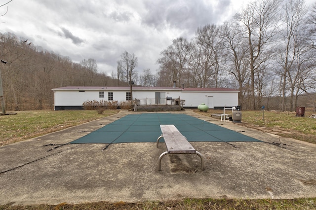 view of pool with a patio area, a covered pool, a yard, and a deck