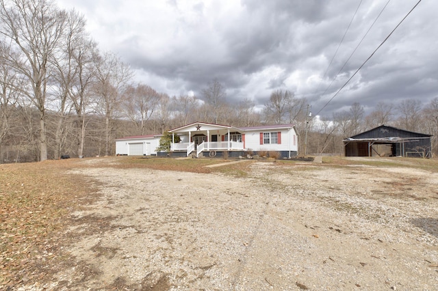 view of front of property with an outbuilding, covered porch, and an attached garage