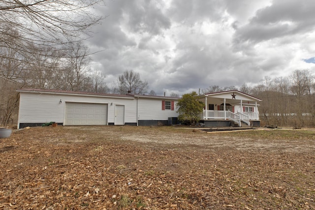 back of house with an attached garage, central AC unit, and a porch