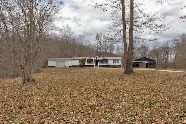 view of front of house featuring a garage, covered porch, and a front yard