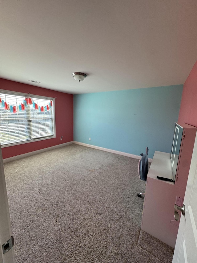 interior space with carpet flooring, visible vents, and baseboards