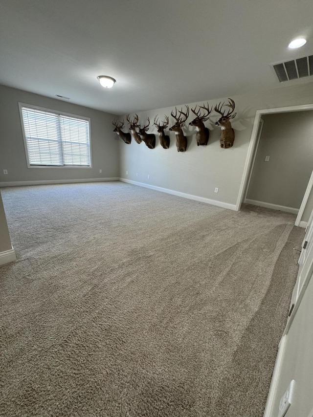 unfurnished room with baseboards, visible vents, and carpet floors