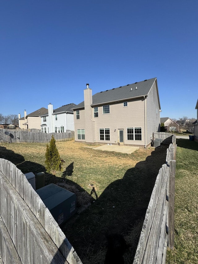 exterior space with central AC unit, a yard, a fenced backyard, a patio area, and a residential view