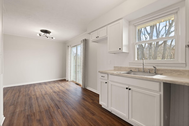 kitchen featuring a healthy amount of sunlight, white cabinets, a sink, and light countertops