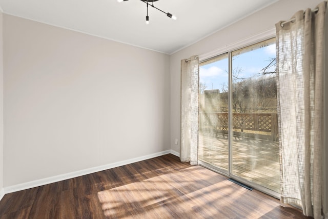 spare room with visible vents, baseboards, and wood finished floors