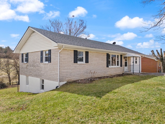 ranch-style home featuring roof with shingles, fence, a front lawn, and brick siding