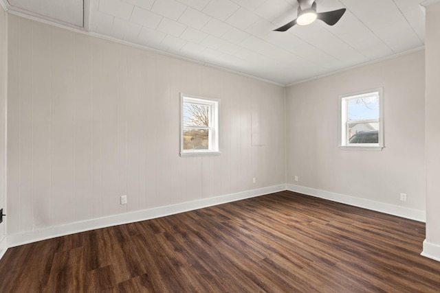 unfurnished room with a ceiling fan, dark wood finished floors, baseboards, and ornamental molding