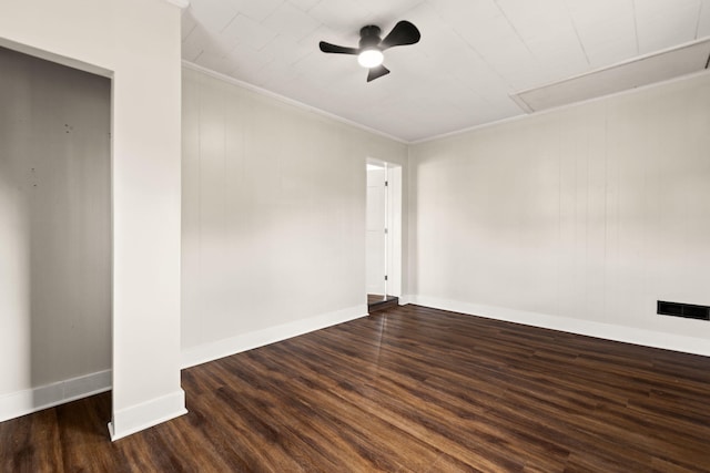 empty room with ceiling fan, wood finished floors, visible vents, baseboards, and ornamental molding