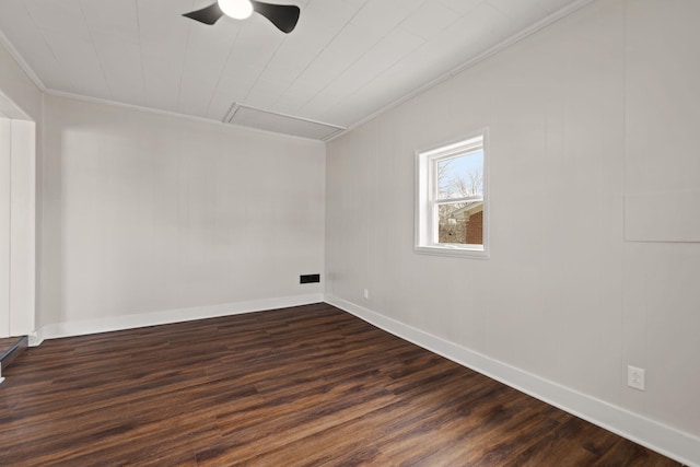 spare room with dark wood-style flooring, visible vents, crown molding, and baseboards