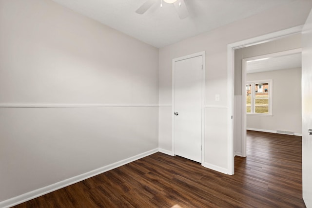 unfurnished bedroom featuring ceiling fan, dark wood finished floors, visible vents, and baseboards