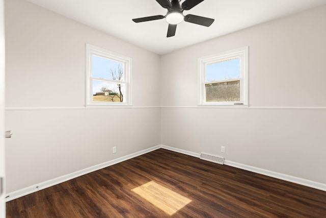 unfurnished room with ceiling fan, dark wood-type flooring, visible vents, and baseboards