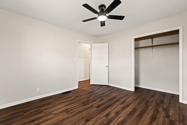 unfurnished bedroom with dark wood finished floors, a closet, visible vents, a ceiling fan, and baseboards