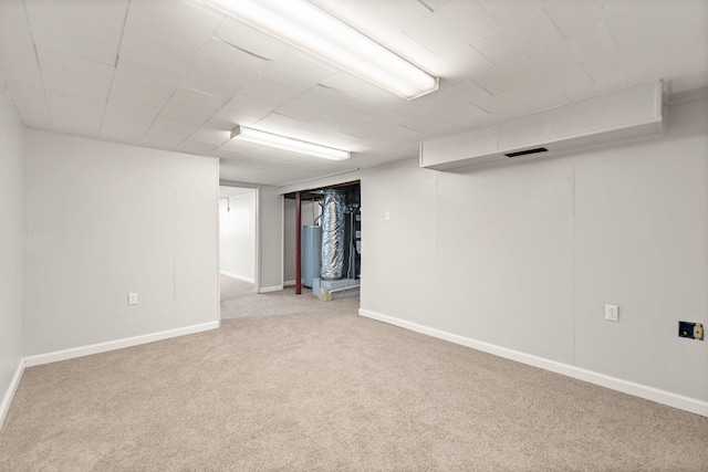 finished below grade area featuring carpet floors, gas water heater, visible vents, and baseboards