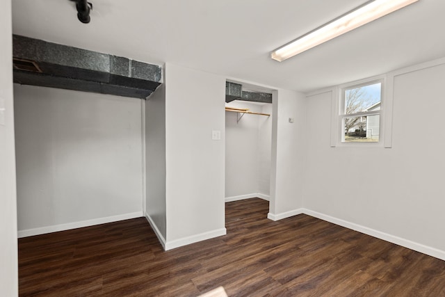 unfurnished bedroom with a closet, wood finished floors, and baseboards