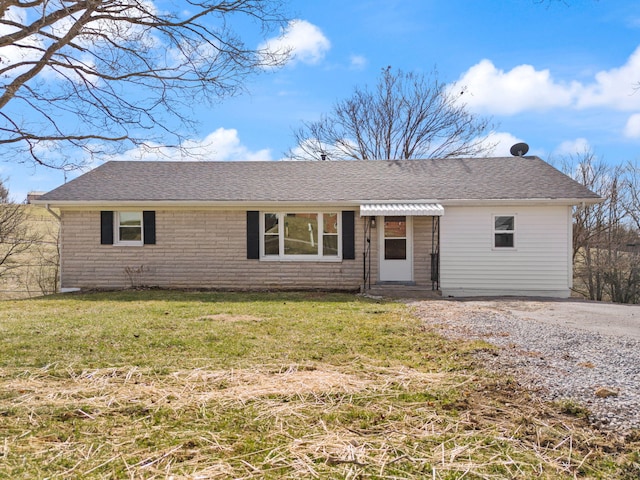 ranch-style house featuring entry steps, a front lawn, a shingled roof, and brick siding