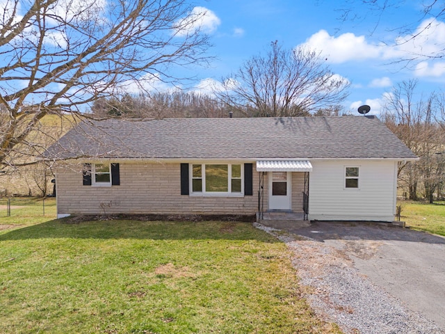 single story home with driveway, a front lawn, and roof with shingles