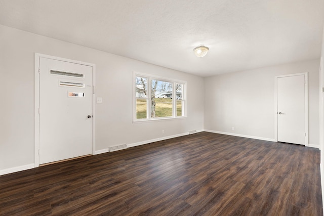 entrance foyer featuring dark wood-type flooring, visible vents, and baseboards