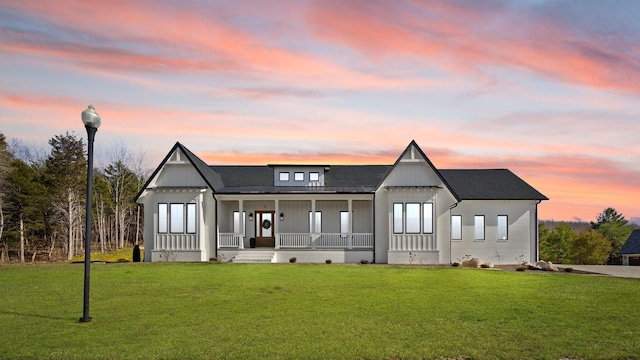 view of front of property with covered porch, crawl space, board and batten siding, and a front yard