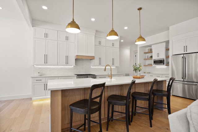 kitchen with open shelves, stainless steel appliances, a sink, and light countertops