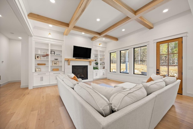 living room with a wealth of natural light, light wood-type flooring, coffered ceiling, and a fireplace