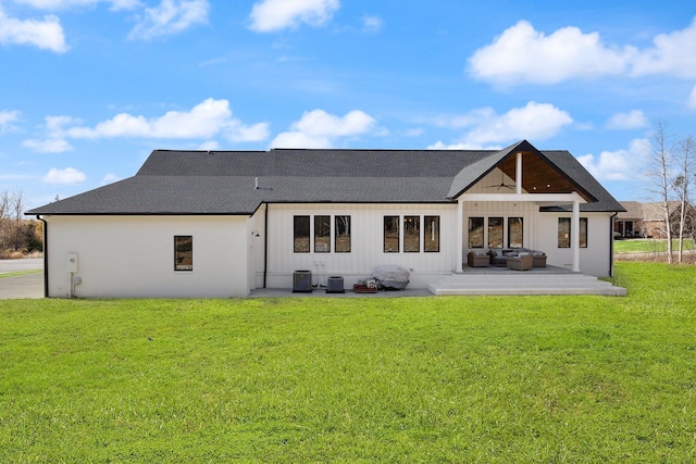 rear view of property featuring ceiling fan, an outdoor hangout area, central AC, a yard, and board and batten siding