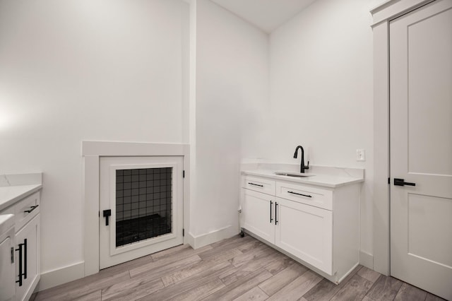 bathroom with vanity, baseboards, and wood finished floors