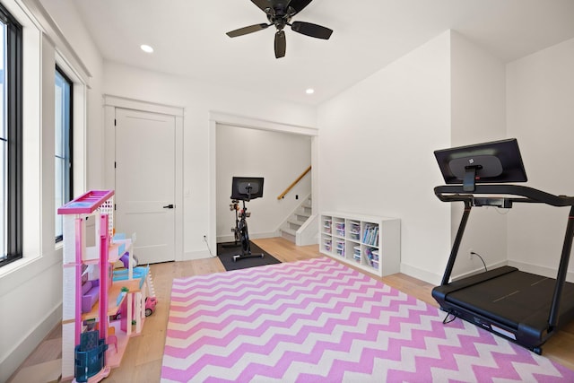 exercise room with baseboards, wood finished floors, a wealth of natural light, and recessed lighting