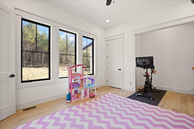 exercise room featuring recessed lighting, visible vents, baseboards, and wood finished floors