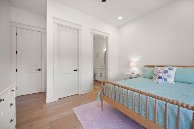 bedroom with light wood-style floors, baseboards, ensuite bathroom, and recessed lighting