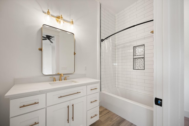 full bath with shower / tub combination, a ceiling fan, wood finished floors, and vanity