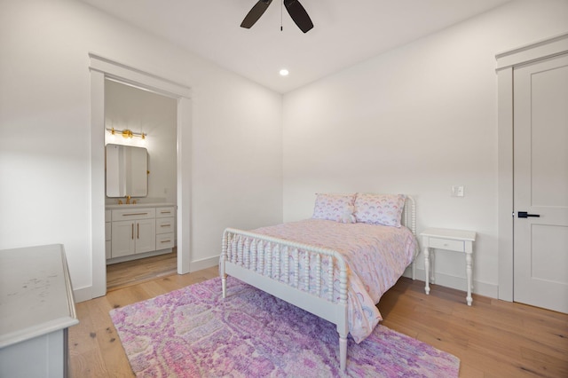 bedroom with baseboards, a ceiling fan, ensuite bath, light wood-style flooring, and recessed lighting