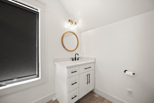 bathroom with wood finished floors, vanity, and baseboards