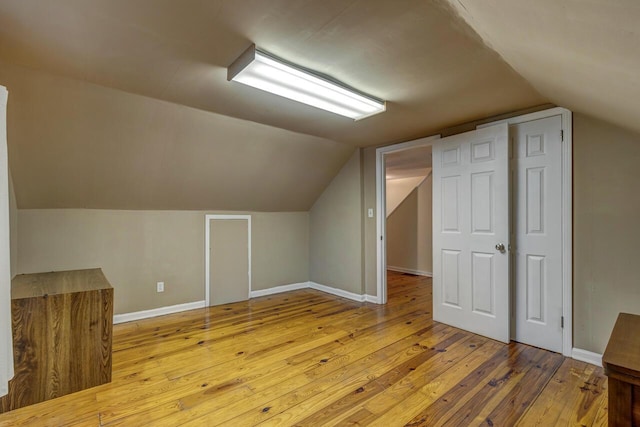 bonus room featuring baseboards, vaulted ceiling, and hardwood / wood-style floors