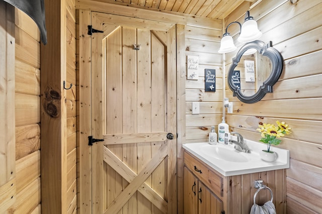 bathroom featuring wooden ceiling, wooden walls, and vanity