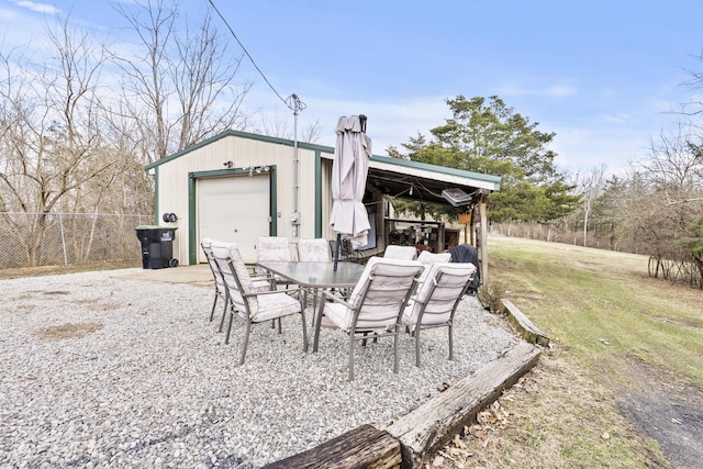 exterior space with a garage, an outdoor structure, and fence