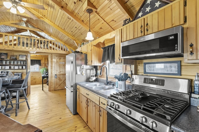 kitchen featuring vaulted ceiling with beams, light wood finished floors, appliances with stainless steel finishes, wood ceiling, and a sink