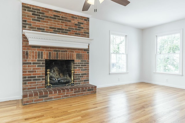 unfurnished living room with a fireplace, baseboards, and wood finished floors