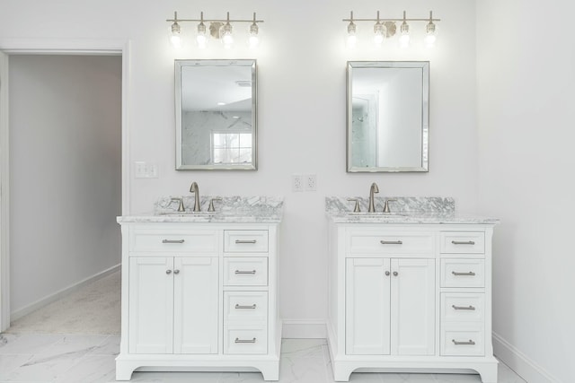 bathroom with marble finish floor, two vanities, a sink, and baseboards