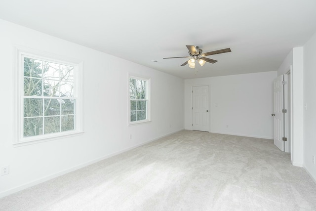 interior space featuring light carpet, ceiling fan, and baseboards